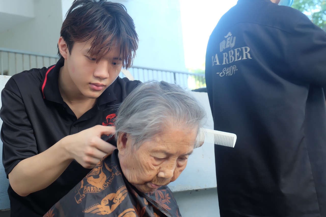 Mỗi buổi cắt tóc miễn phí diễn ra từ 3h đến 6h chiều tại sân chung cư Phước Lý (quận Cẩm Lệ, TP Đà Nẵng). Ảnh: Mai Hương