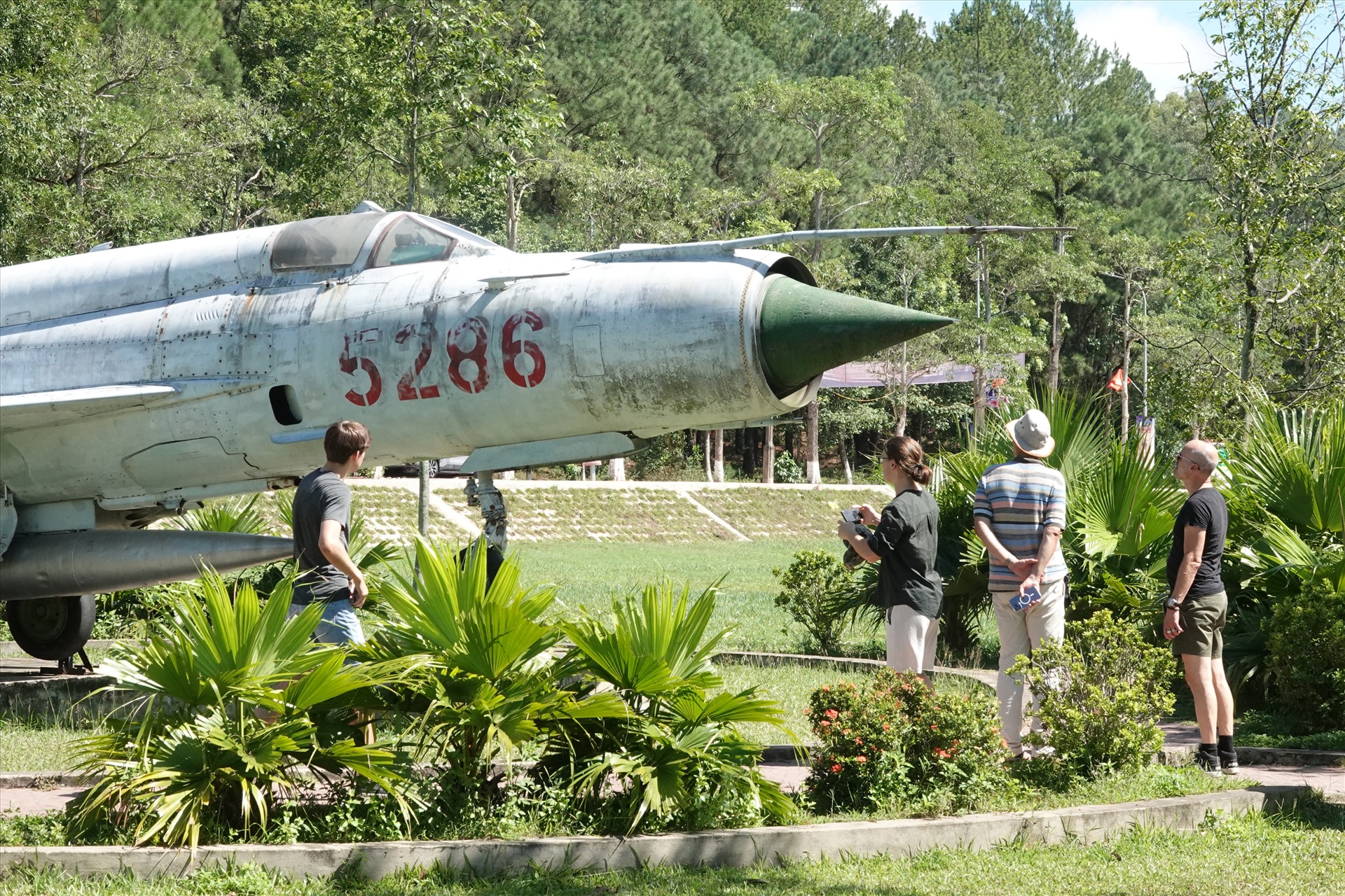 Khách Tây tham quan máy bay là chứng tích chiến tranh được trưng bày tại di tích Ngã ba Đồng Lộc. Ảnh: Trần Tuấn. 