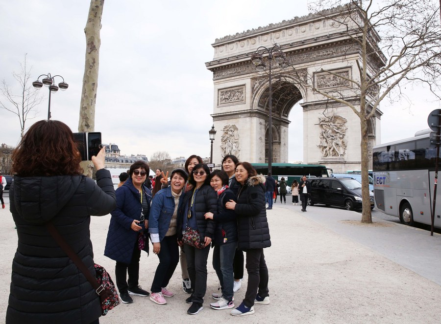 Đoàn khách Trung Quốc chụp ảnh trước Khải Hoàn Môn ở Paris, Pháp vào tháng 3.2019. Ảnh: Xinhua