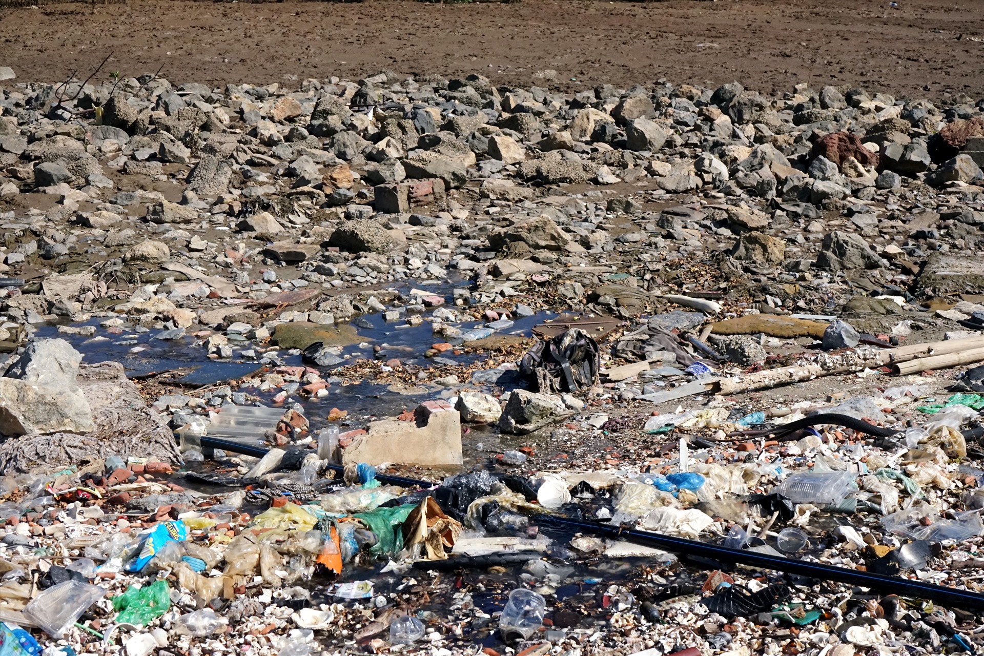 Tương tự tại khu vực thôn Ninh Phú, xã Đa Lộc rác thải bị dồn ứ công với nước thải của cơ sở chế biến hải sản chảy ra, khiến bốc mùi hôi thối, rất khó chịu. Ảnh: Quách Du