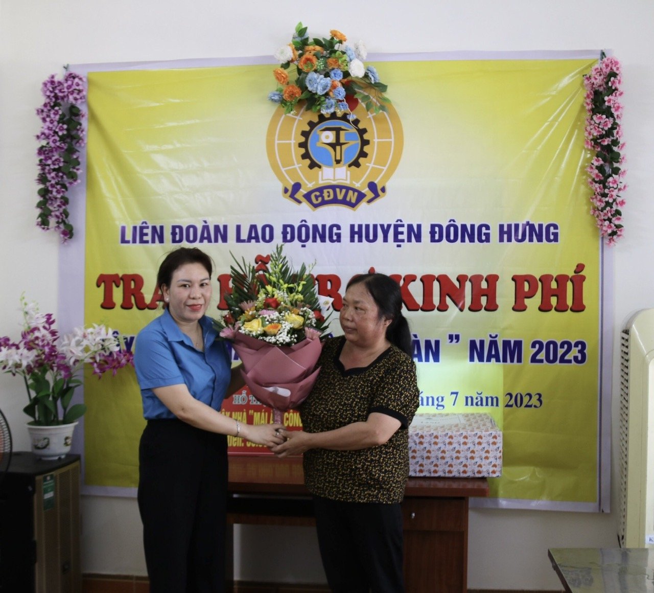 Lãnh đạo LĐLĐ huyện Đông Hưng tặng hoa và quà động viên chị Thêu. Ảnh: Bá Mạnh