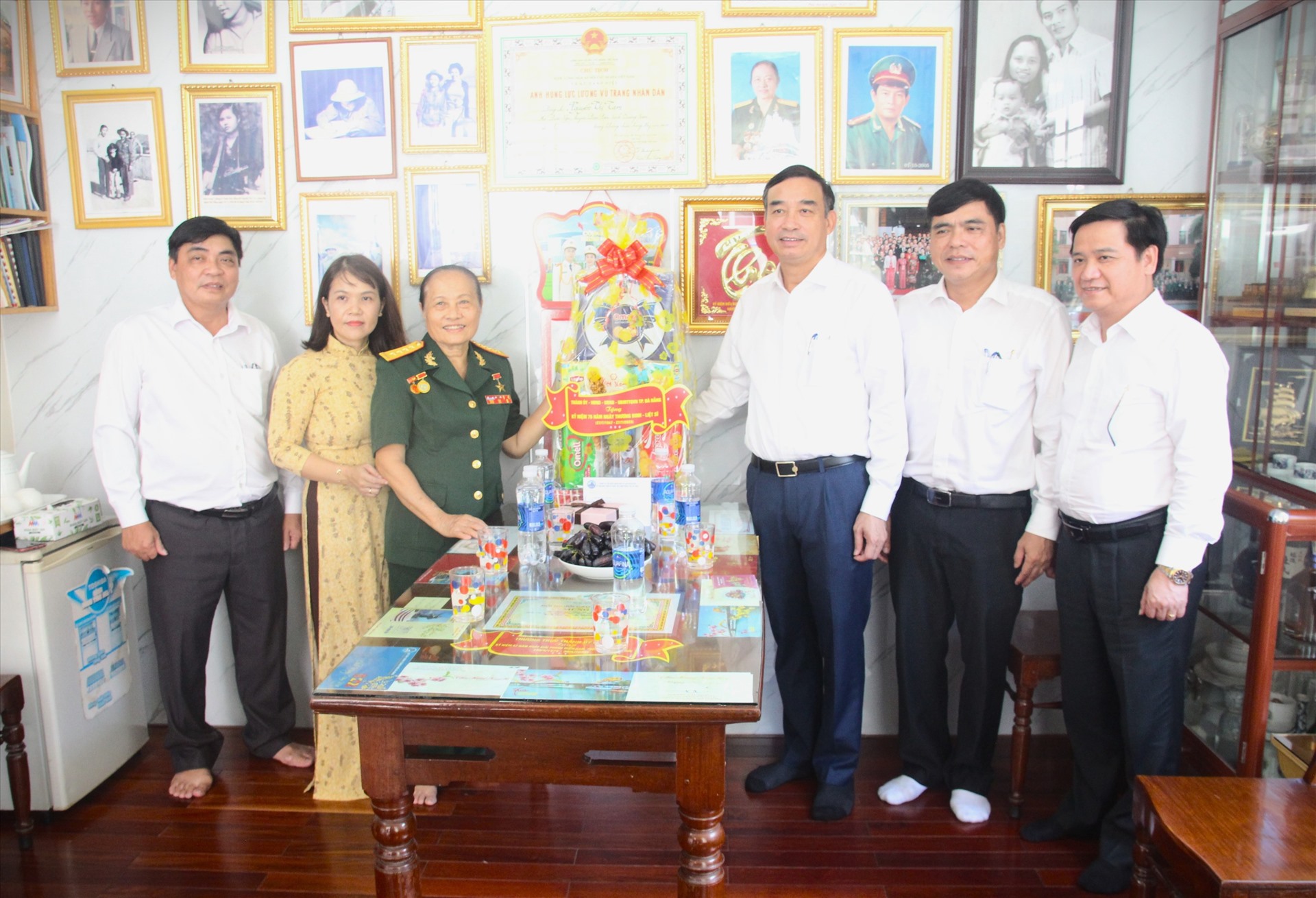 Chủ tịch UBND thành phố Lê Trung Chinh (thứ 3, bên phải sang) thăm, tặng quà gia đình Anh hùng Lực lượng vũ trang nhân dân Nguyễn Thị Tám (thứ 3, bên trái sang). Ảnh: Ngọc Quốc 