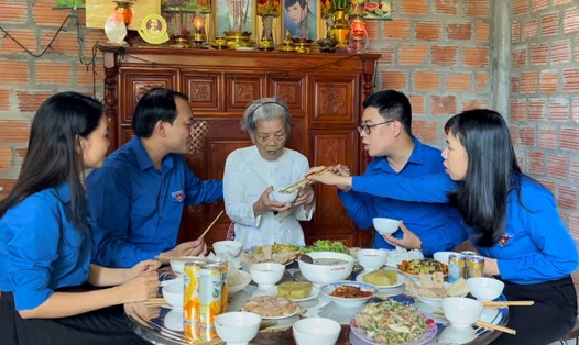 Mẹ Việt Nam anh hùng Dương Thị Hường ăn bữa cơm do các đoàn viên thanh niên nấu. Ảnh: Hưng Thơ.