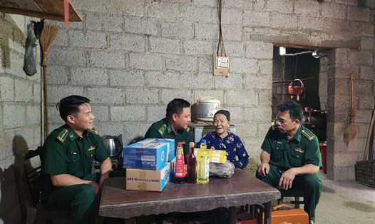 Cán bộ Đồn Biên phòng Cửa khẩu Trà Lĩnh đến thăm mẹ Hoàng Thị Phấn. Ảnh: Tân Văn.
