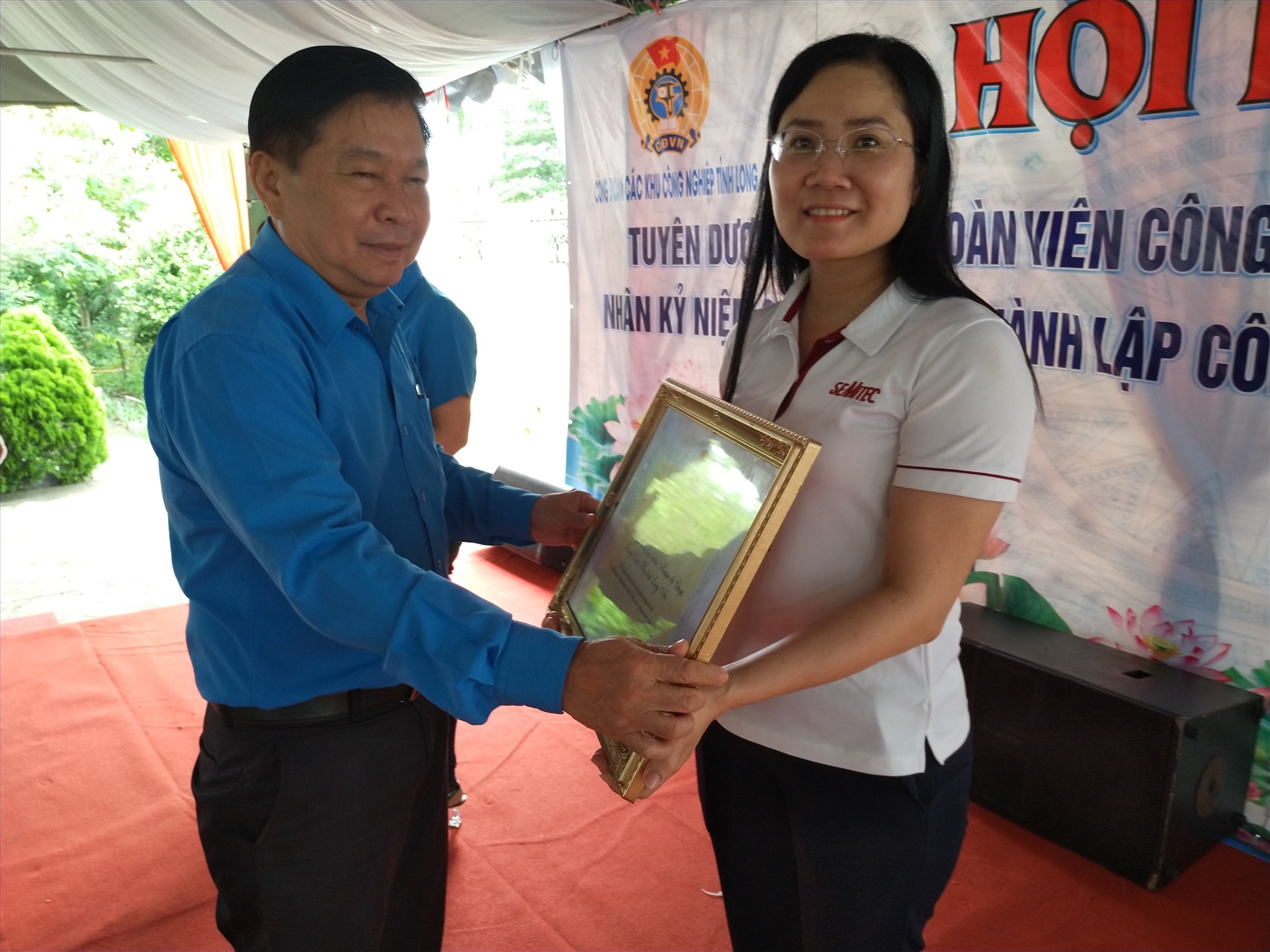 Chủ tịch LĐLĐ tỉnh Long An - ông Nguyễn Văn Quí - trao Bằng khen của Tổng LĐLĐ Việt Nam cho công đoàn viên xuất sắc. Ảnh: K.Q