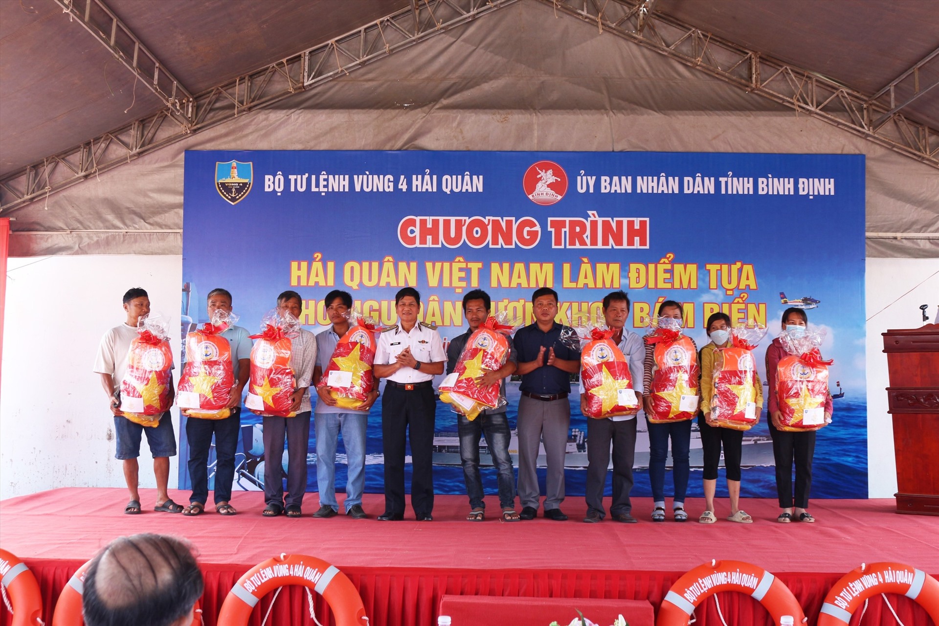 Thủ trưởng BTL Vùng 4 và lãnh đạo địa phương trao quà tặng gia đình ngư dân có hoàn cảnh khó khăn. Ảnh: Vũ Bằng