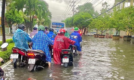 Người dân dắt bộ xe máy trên tuyến đường Nguyễn Trung Trực vì xe bị ngập nước chết máy. Ảnh: Bạn đọc