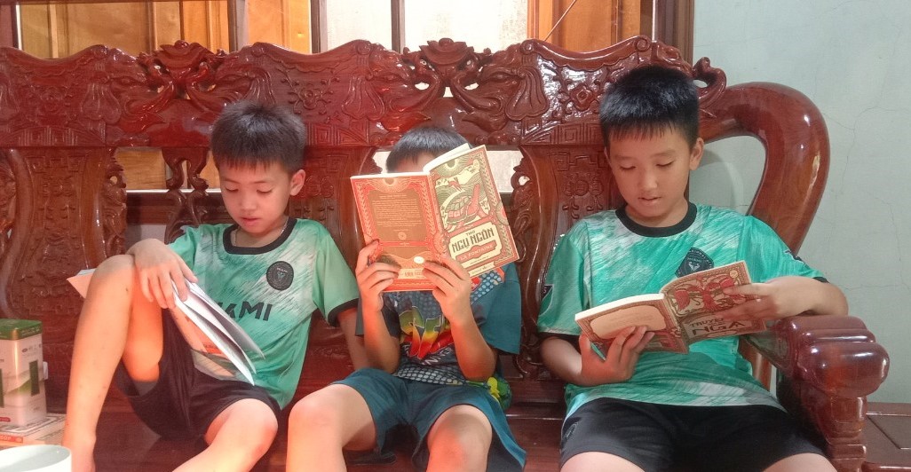 Sau khi chọn sách tại thư viện “Trời xanh ngập nắng“, trẻ em có thể ngồi thoải mái đọc sách tại phòng khách gia đình thầy Trung. Ảnh: Hữu Vi