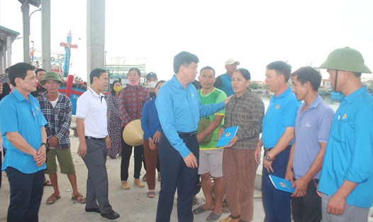 Chủ tịch LĐLĐ tỉnh Nghệ An Kha Văn Tám trao hỗ trợ và động viên đoàn viên nghiệp đoàn nghề cá tại Quỳnh Lưu bị thiệt hại do hỏa hoạn. Ảnh: Vân Nam
