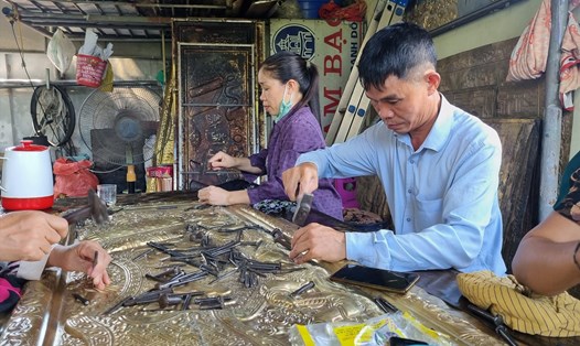 Ông Hoàn cùng lao động tại xưởng hoàn thiện sản phẩm chạm bạc Đồng Xâm. Ảnh: Lương Hà