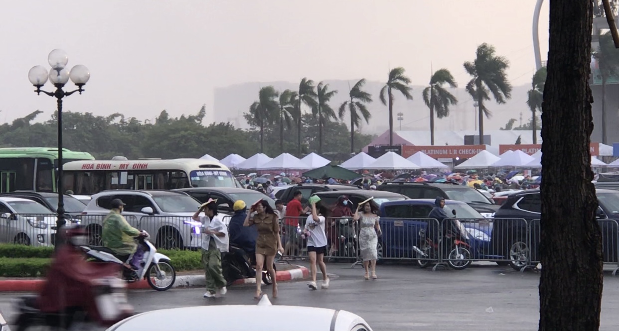 Khán giả vội vã tìm chỗ trú mưa phía ngoài sân vận động Mỹ Đình.