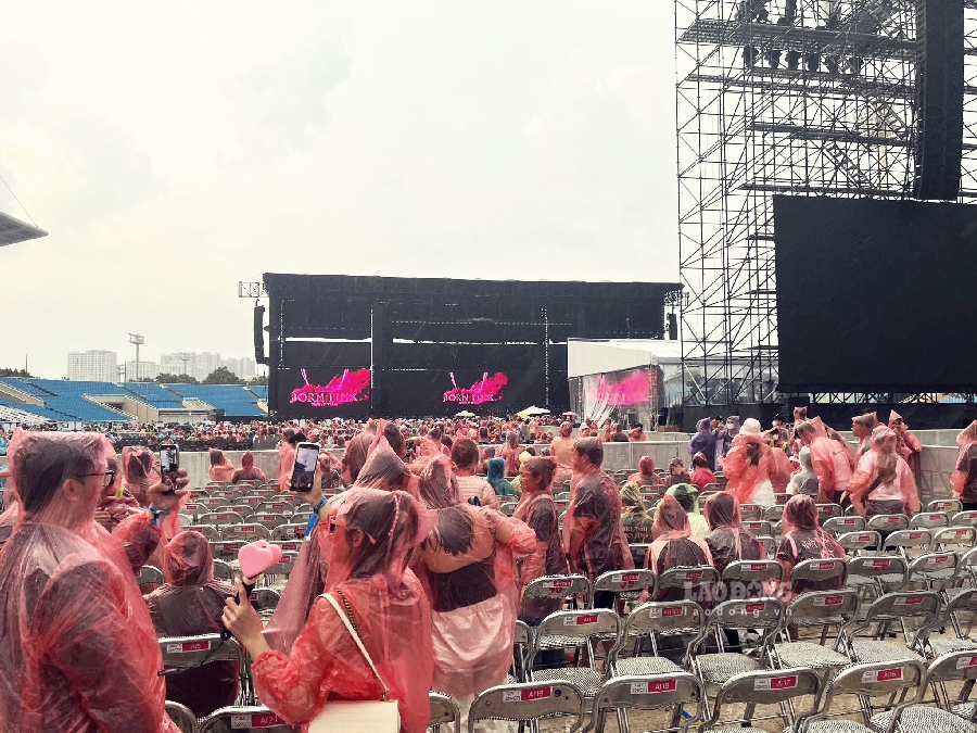 Bất chấp trời đổ mưa, nhiều người hâm mộ đã chuẩn bị sẵn áo mưa, sẵn sàng “cố thủ” chờ xem đêm nhạc của nhóm. Ảnh: Thùy Trang