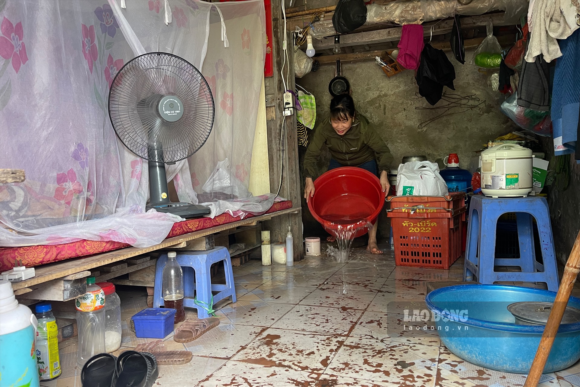 Chị Phương phải đổ nước ra nền nhà để nằm ngủ trong ngày nắng nóng. Ảnh: Khánh An