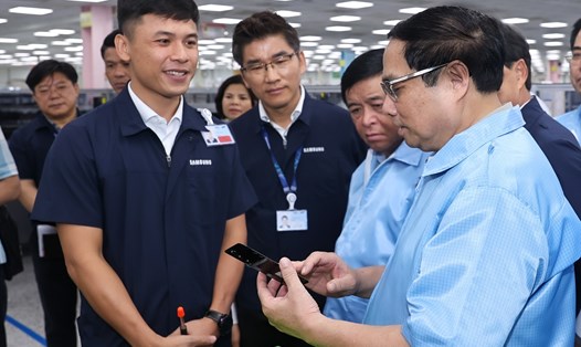 Thủ tướng Phạm Minh Chính tham quan dây chuyền sản xuất thiết bị điện tử của công ty, trao đổi với các nhân viên Samsung về tình hình sản xuất. Ảnh: VGP