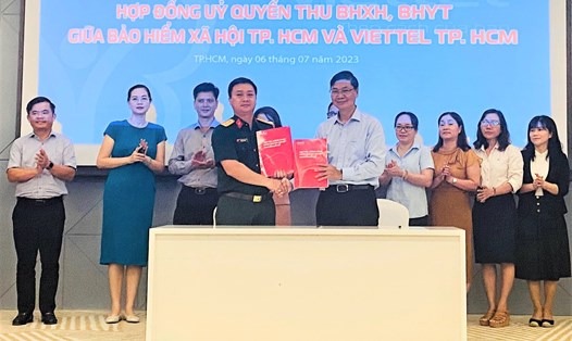 Đại diện BHXH và Viettel TP Hồ Chí Minh ký hợp đồng ủy quyền thu BHXH tự nguyện, BHYT hộ gia đình. Ảnh: Đức Long