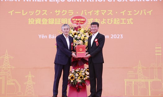 Chủ tịch UBND tỉnh Yên Bái Trần Huy Tuấn (phải) trao chứng nhận đăng ký đầu tư dự án và tặng hoa chúc mừng Công ty Cổ phần Erex. Ảnh: Bảo Nguyên
