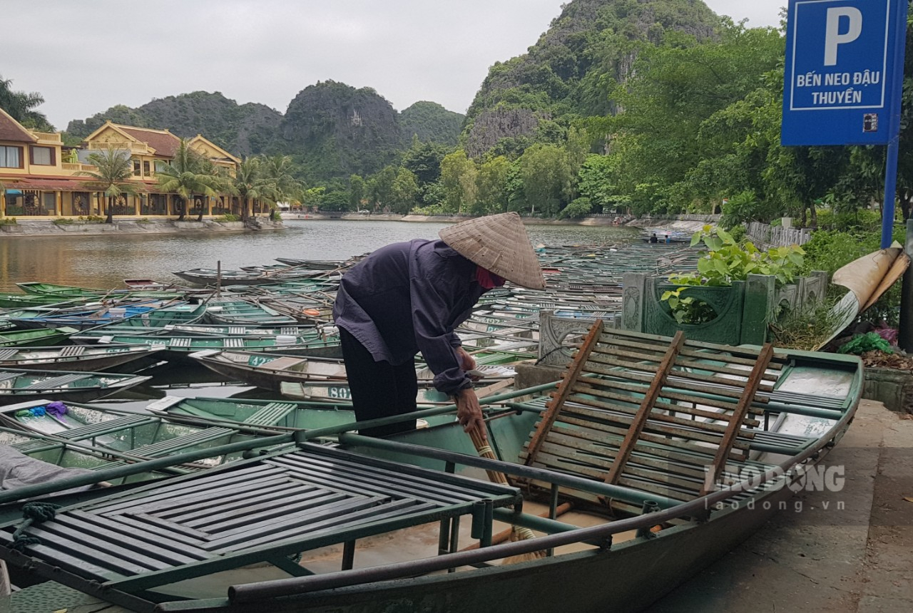 Nhiều chủ đò tranh thủ vệ sinh, sửa chữa lại những chiếc đò của gia đình. Ảnh: Diệu Anh