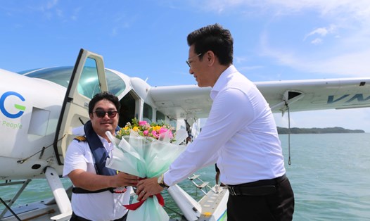 Ông Nguyễn Việt Dũng - Bí thư Huyện ủy, Chủ tịch UBND huyện đảo Cô Tô - tặng hoa chúc mừng cơ trưởng trong chuyến bay thương mại đầu tiên đến với Cô Tô. Ảnh: Thu Báu