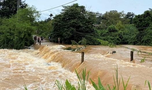 Đã hơn 2 ngày qua, hơn 100 hộ dân ở bon N'Jang Bơ bị cô lập do mưa lũ gây ngập cây cầu. Ảnh: Y Sơn