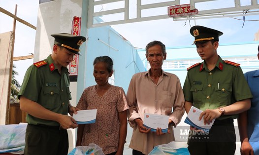 Đoàn thanh niên Công an tỉnh trao tiền hỗ trợ cho các hộ dân bị thiệt hại vì mưa dông. Ảnh: Công an Kiên Giang