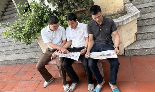 Anh Hoàng Văn Vĩnh cùng đồng nghiệp đọc Báo Lao Động sau ca làm việc. Ảnh: Kiều Vũ