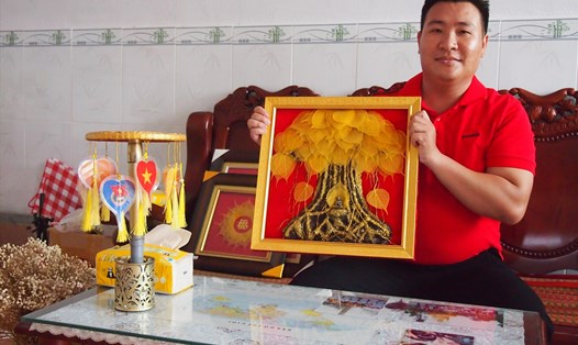 Đặng Duy Khánh (Vĩnh Hiệp, thị xã Vĩnh Châu, Sóc Trăng) bên tranh từ lá bồ đề. Ảnh: Phương Anh