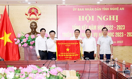 Phó Chủ tịch UBND tỉnh Nghệ An Bùi Đình Long trao Cờ thi đua của Chính phủ cho Sở GD-ĐT Nghệ An. Ảnh: Hải Đăng