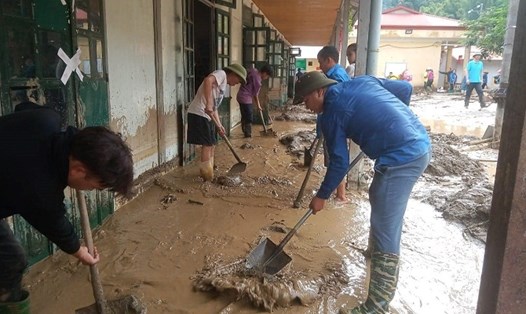 Các thầy cô trong vùng cùng các ban ngành, bà con xung quanh dọn dẹp bùn đất sau mưa lũ tại trường Hồ Bốn. Ảnh: Yenbai.gov.vn

