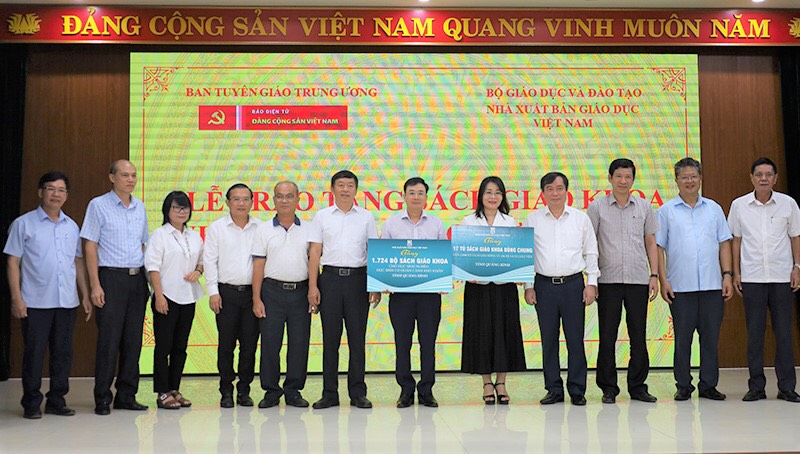 Các đại biểu của đoàn công tác trao biển tặng SGK cho lãnh đạo Sở Giáo dục-Đào tạo Quảng Bình. Ảnh: Thuỷ Nguyễn