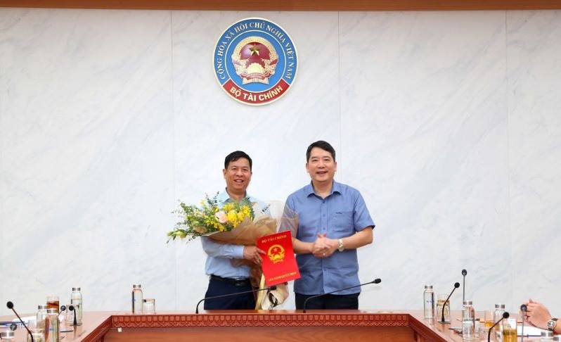 Thứ trưởng Bộ Tài chính Cao Anh Tuấn (bên phải) trao quyết định Phó Vụ trưởng Vụ Đầu tư cho ông Bùi Việt Hưng. Ảnh: Đức Minh.
