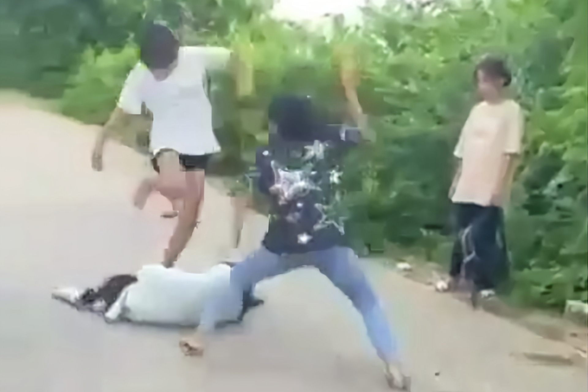 Trong clip trước đó, dù nữ sinh bị đánh đã nằm bất động, 2 nữ sinh vân không ngừng đánh. Ảnh cắt từ clip.