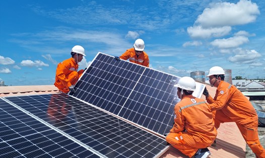 Công nhân Tổng Công ty Điện lực TP Hồ Chí Minh lắp đặt hệ thống điện mặt trời trên mái nhà. Ảnh: Nam Dương