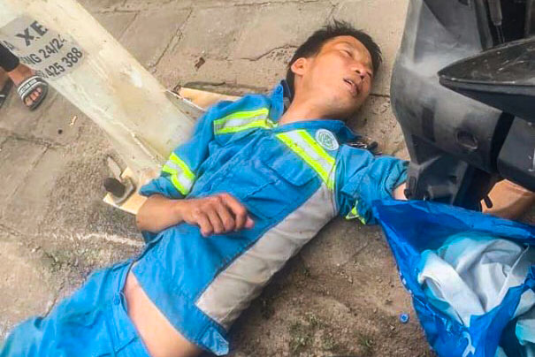 Nam công nhân vệ sinh môi trường nằm bất động trên vỉa hè sau khi bị tai nạn giao thông. Ảnh: Urenco