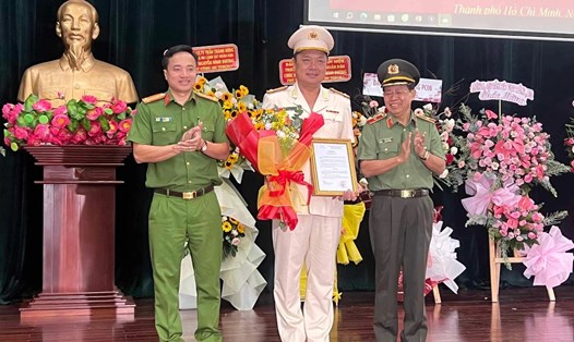 Thiếu tướng Trần Đức Tài (bên bìa phải), Phó Giám đốc Công an TPHCM, thừa ủy quyền Bộ trưởng Bộ Công an trao quyết định bổ nhiệm thượng tá Nguyễn Đình Dương (đứng giữa).