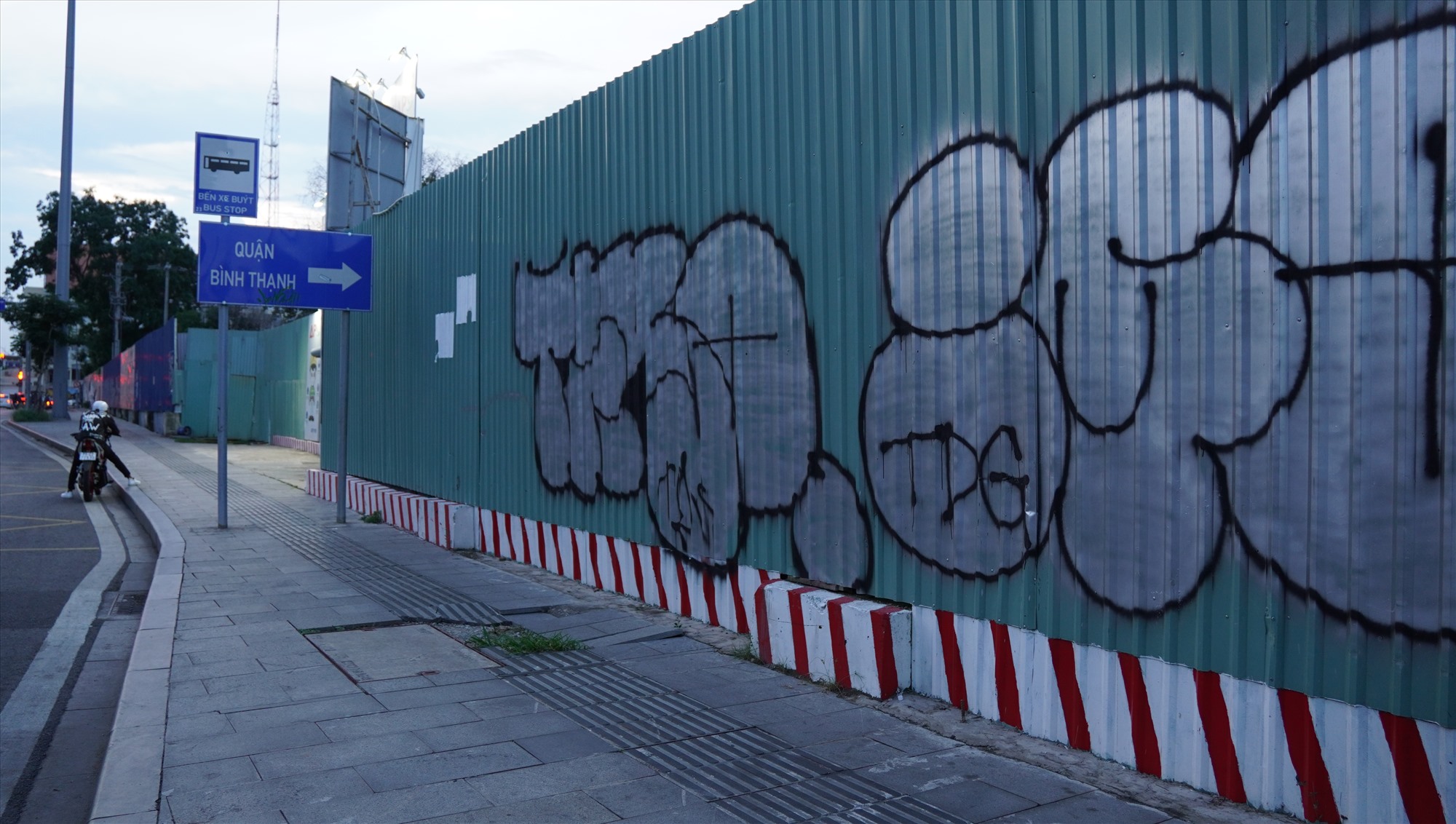 Nét vẽ bằng sơn xịt màu đỏ và đen, mang bóng dáng của graffiti - thuộc nhóm các loại hình nghệ thuật đường phố.
