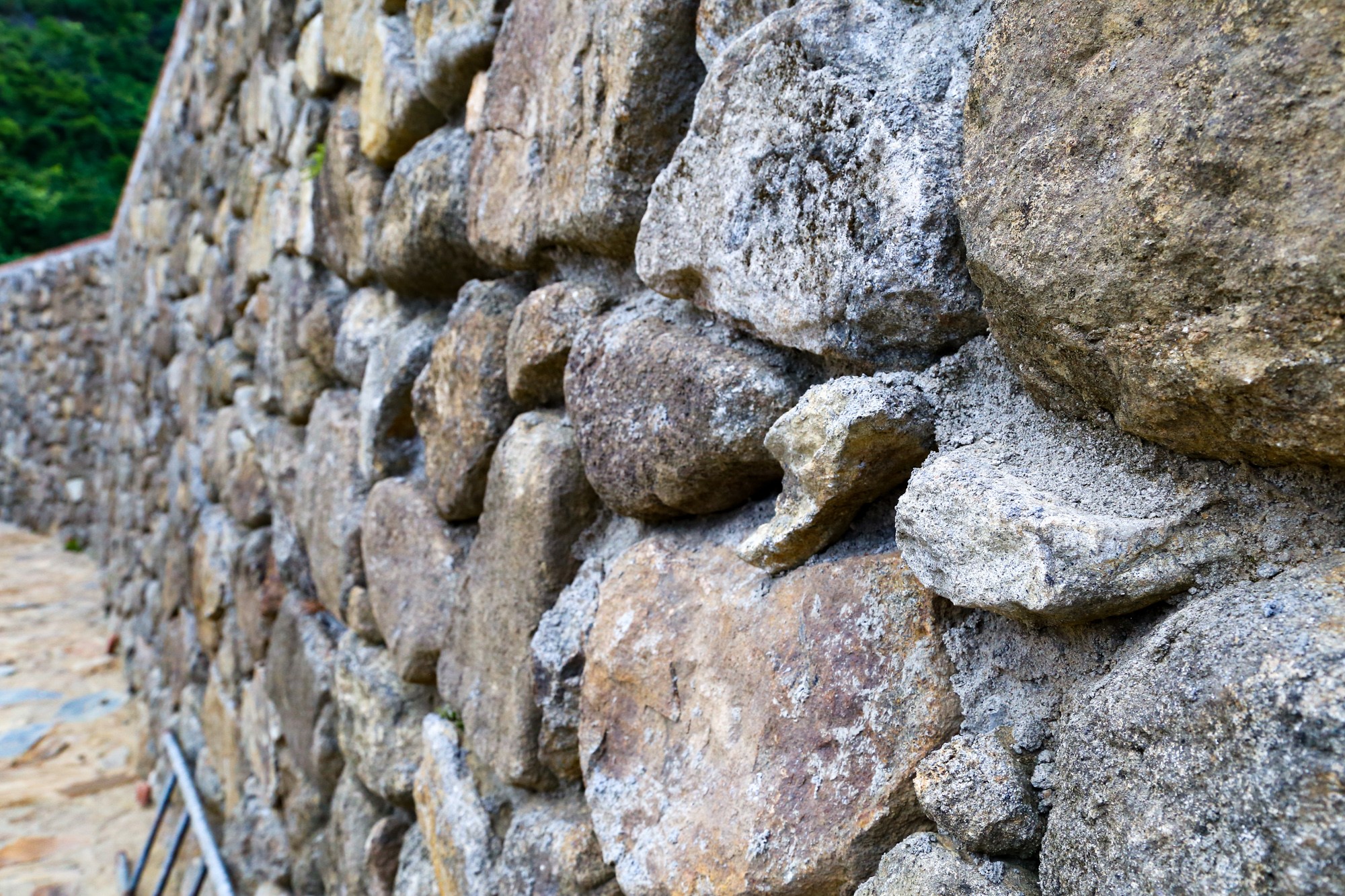 Hệ thống tường di tích được phục chế bằng đá mồ côi với bề mặt bằng phẳng để đảm bảo mỹ quan.
