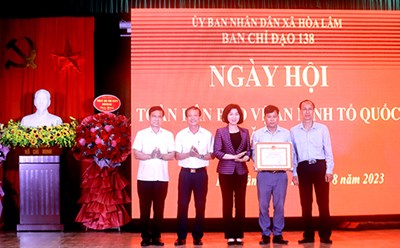 Phó Chủ tịch Thường trực HĐND Thành phố Phùng Thị Hồng Hà trao bằng khen của UBND Thành phố tặng tập thể cán bộ và nhân dân xã Hòa Lâm. Ảnh: Cổng TTĐT Hà Nội