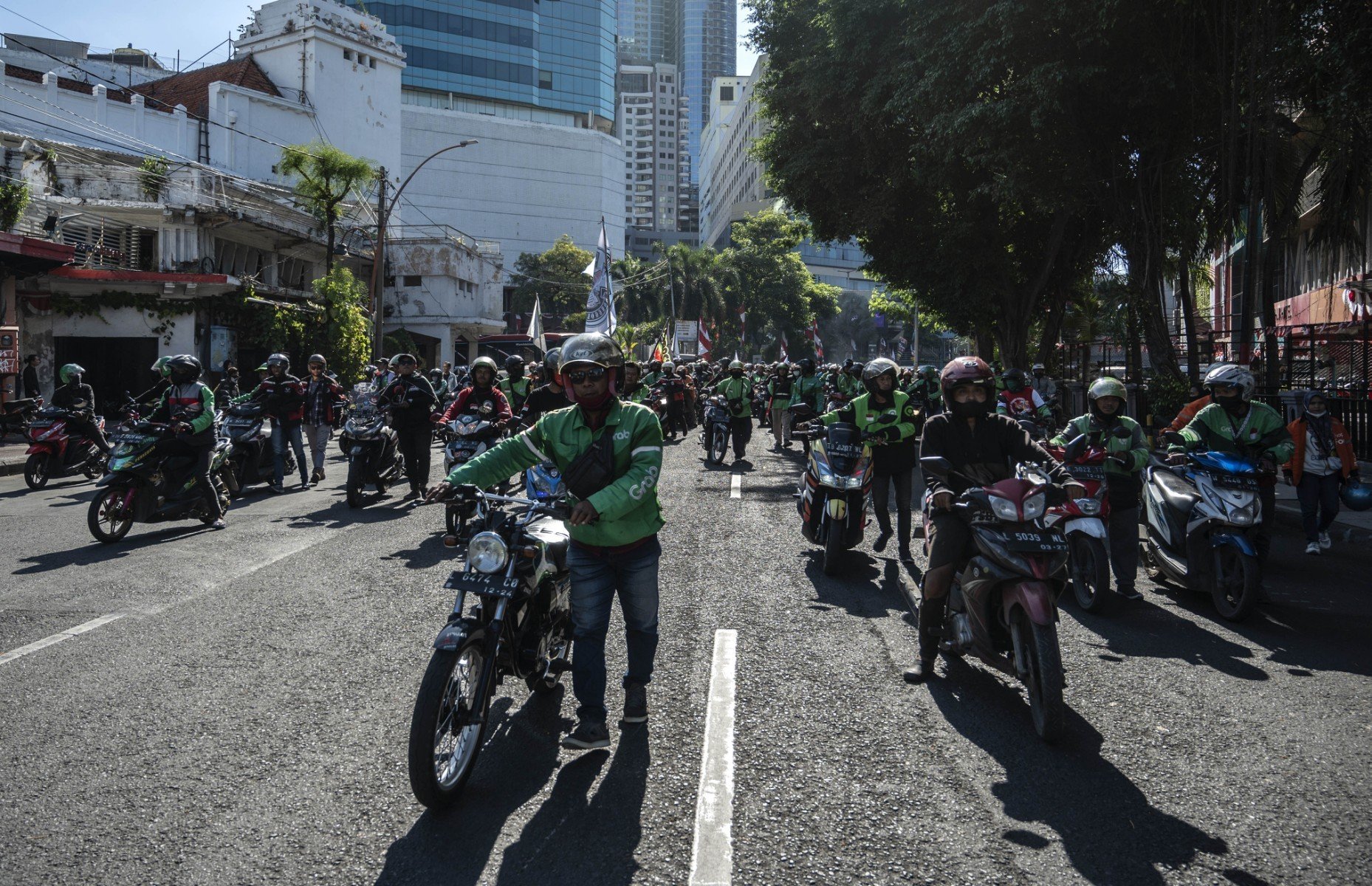 Tài xế xe ôm công nghệ từng là một nghề "hot" khi mang lại một nguồn thu nhập ổn định mà không cần đầu tư nhiều ngoài một chiếc điện thoại thông minh và xe máy. Tuy nhiên, ở thời điểm hiện tại, nhiều tài xế đã phải tìm thêm những cách khác để đảm bảo mức thu nhập ổn định. Ảnh: AFP