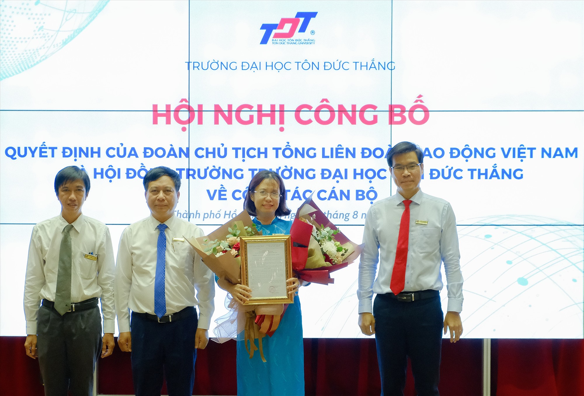 Lãnh đạo TDTU trao quyết định, tặng hoa chúc mừng Tiến sĩ Đồng Sĩ Thiên Châu. Ảnh: Nam Dương