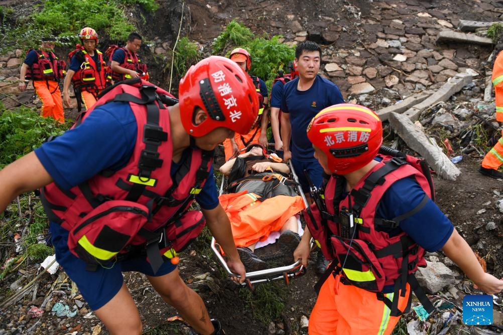Lực lượng cứu hộ chuyển một dân làng bị thương ở quận Môn Đầu Câu, Bắc Kinh, ngày 1.8.2023. Ảnh: Xinhua