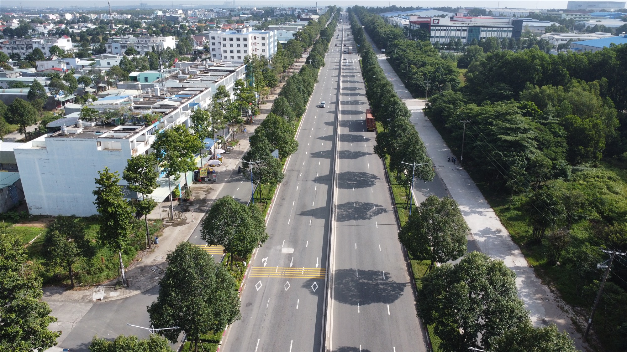 Đường Mỹ Phước Tân Vạn đoạn từ vòng xoay Định Hòa (thành phố Thủ Dầu Một) đến Trung tâm hành chính huyện Bàu Bàng được phủ xanh bở 4 hàng cây hai bên.