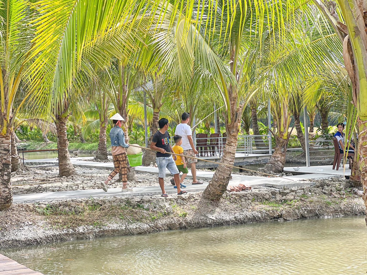 Du khách trải nghiệm câu cá giữa vườn dừa. Ảnh: Tạ Quang