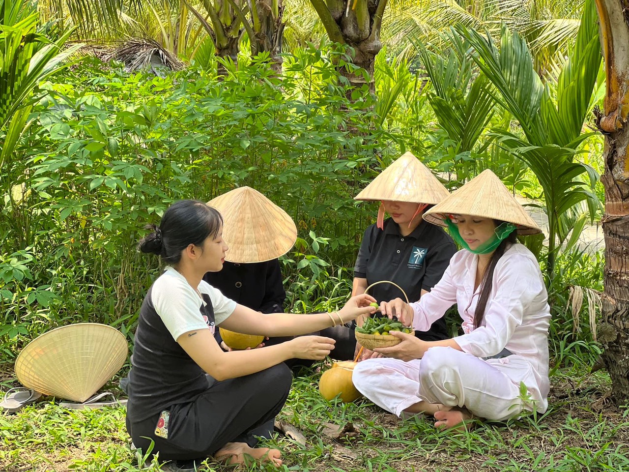 Nhiều du khách thích thú khi được thưởng thức nước dừa, trái cây tại vườn. Ảnh: Tạ Quang