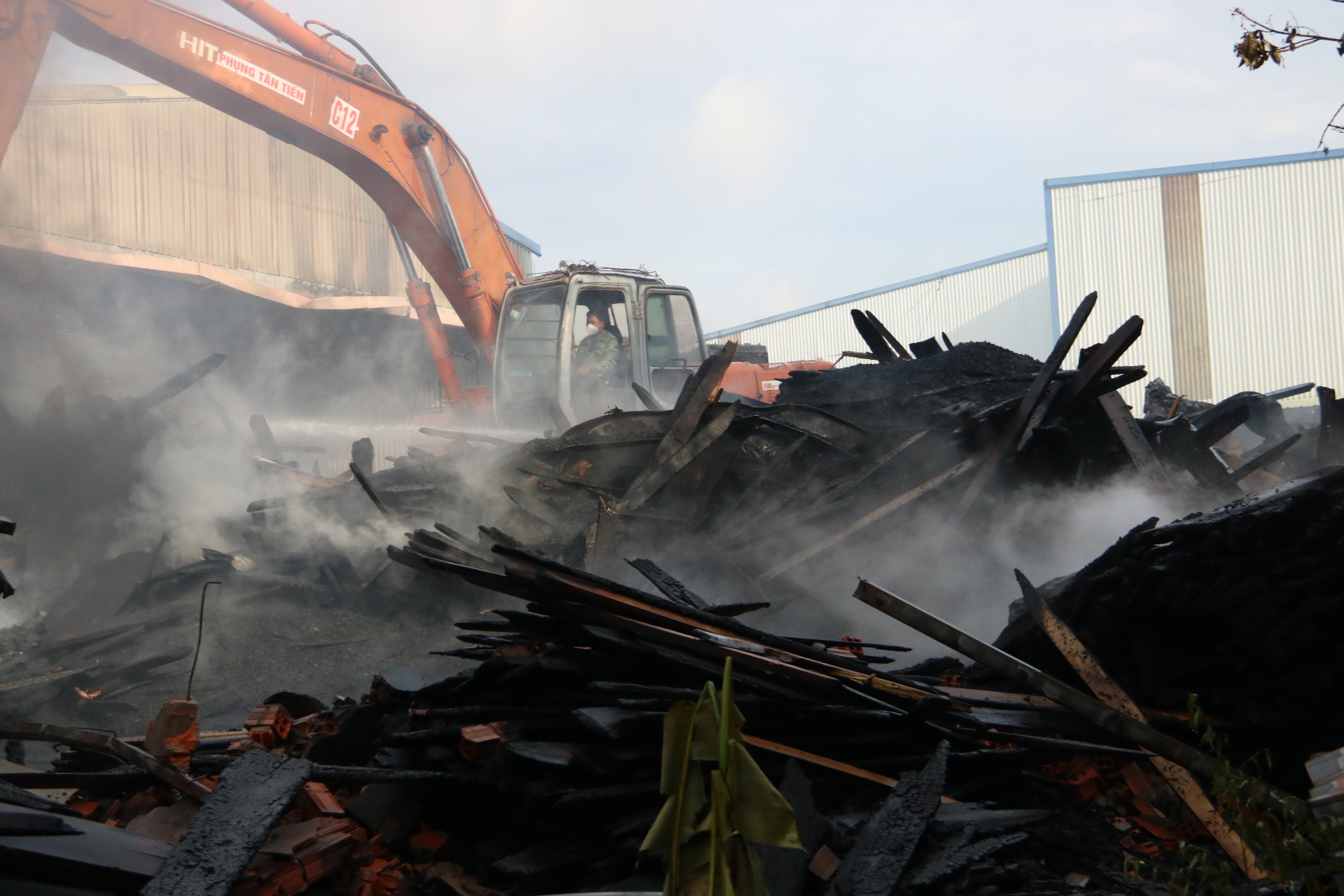 Cơ sở sản xuất đồ gỗ bị thiệt hại nặng, nhiều khối gỗ chất đống còn cháy âm ỉ. Lực lượng chức năng phải điều xe múc vào đào xới lên để đưa nước dập tặt hoàn toàn đám cháy.