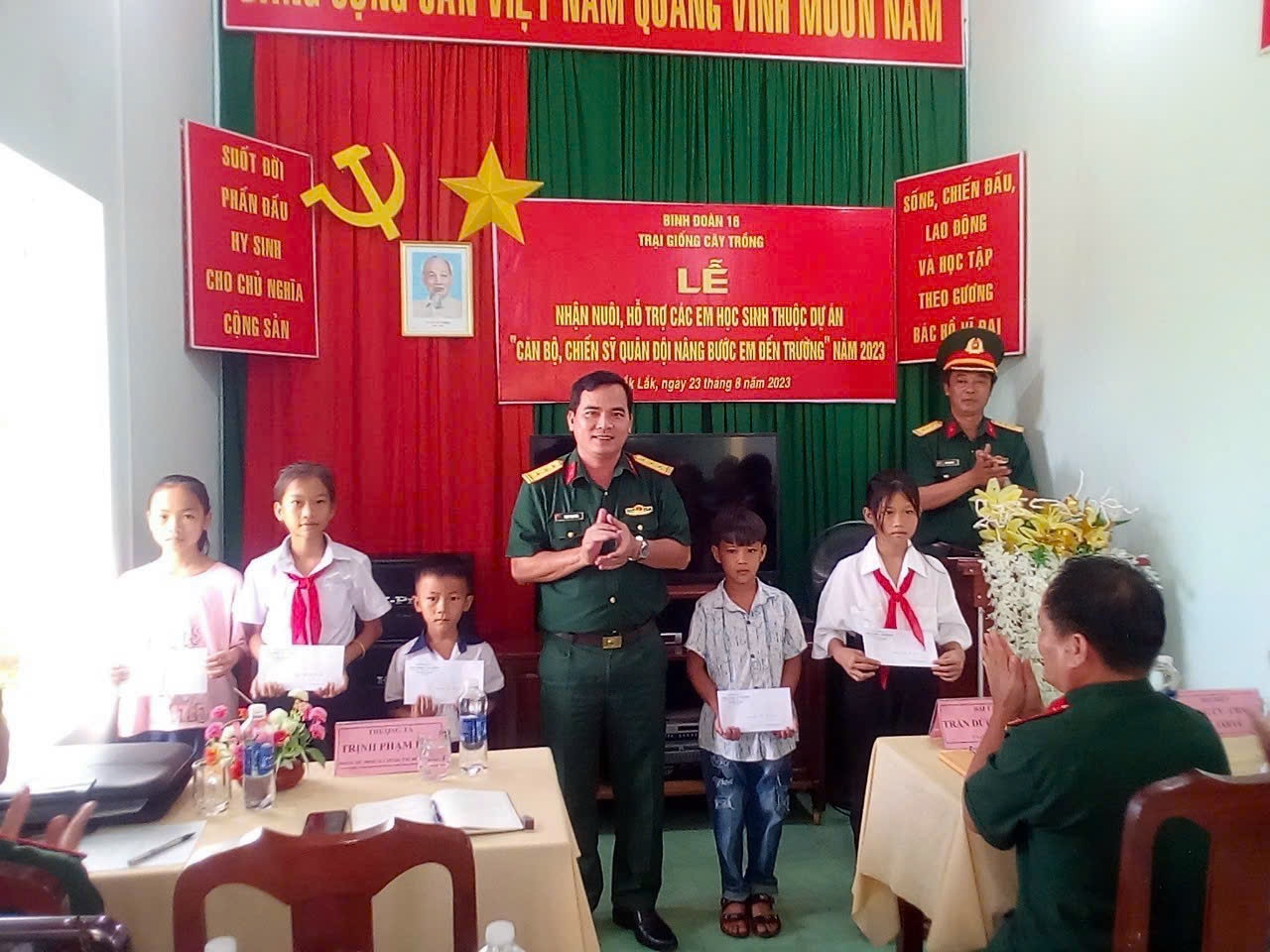  Thượng tá Trịnh Phạm Hoà, Phó chủ nhiệm Chính trị Binh đoàn 16 trao Quyết định nhận nuôi, hỗ trợ các em học sinh.  Ảnh: Hồng Thắm