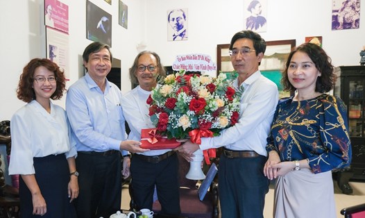 Lãnh đạo thành phố Đà Nẵng thăm và chúc mừng nhà văn Vĩnh Quyền (thứ 3 từ trái) tại nhà riêng. Ảnh: Mai Quang