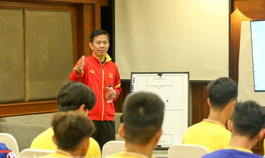 Huấn luyện viên Hoàng Anh Tuấn phổ biến kế hoạch hoạt động cho các cầu thủ tại cuộc họp nhanh trước buổi tập chuẩn bị cho chung kết U23 Đông Nam Á 2023. Ảnh: VFF
