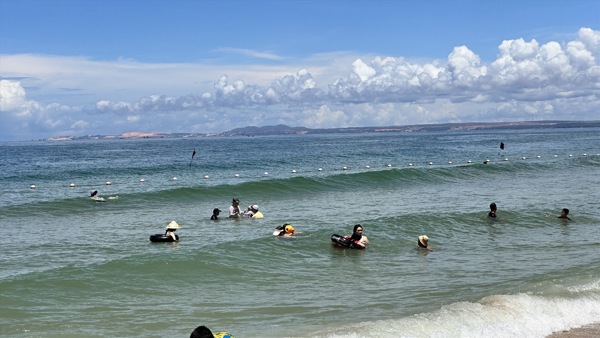 Du khách tắm biển Phan Thiết trong vùng an toàn được giới hạn bằng dây phao. Ảnh: Duy Tuấn