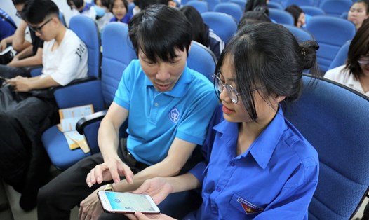 Cán bộ BHXH Việt Nam hướng dẫn người dân cài đặt ứng dụng VssID. Ảnh: BHXH VN