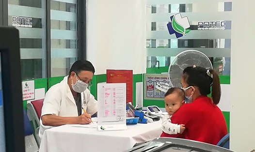 Bác sĩ thăm khám cho bệnh nhi có các biểu hiện mắc cúm mùa. Ảnh: Hương Giang